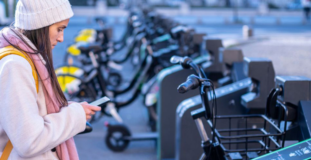 Vue d'un quartier urbain dynamique avec des personnes circulant à vélo sous un soleil doux, symbole de mobilité durable