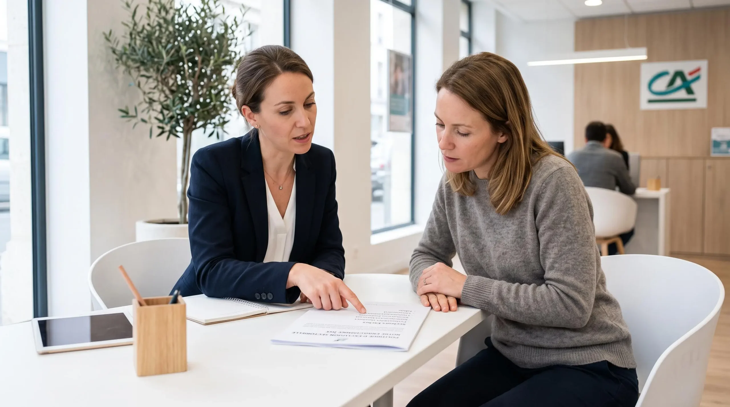 Conseillère bancaire présentant un document d'exclusions sectorielles à une cliente dans un espace conseil d'agence bancaire coopérative